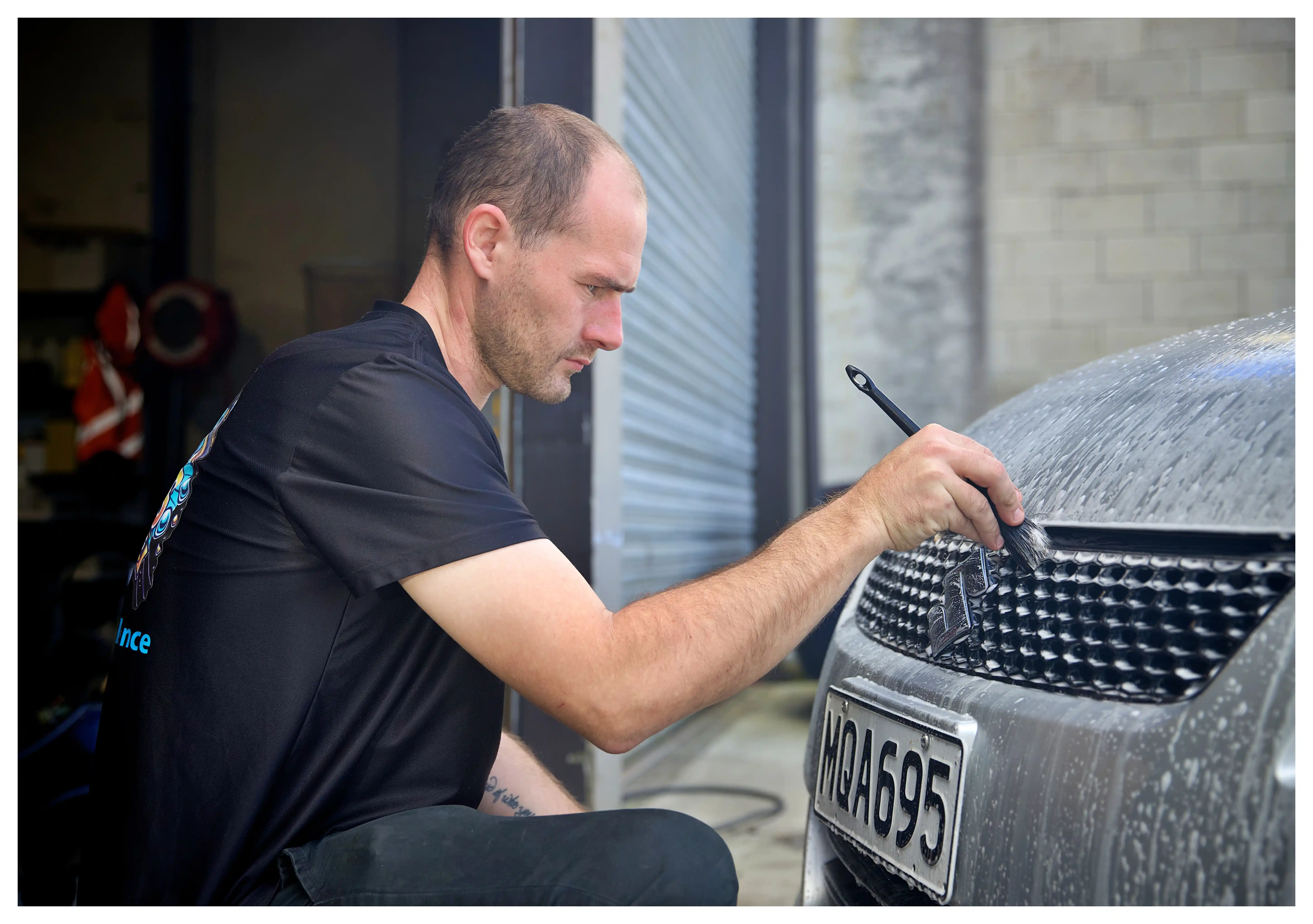 Professional car detailing service showing a pristine vehicle being cleaned